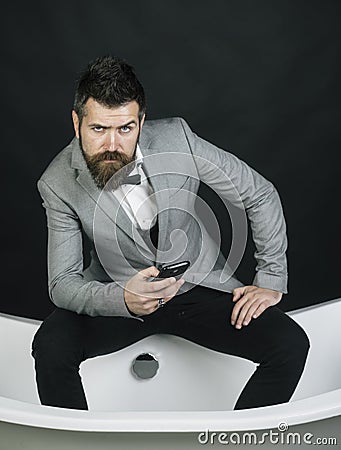 Hipster with stylish appearance in luxury old fashioned bathtub. Stock Photo