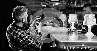 Hipster taking photo drunk friend. Drunk friends in bar. Fall asleep at bar counter. Take photo to remember party Stock Photo