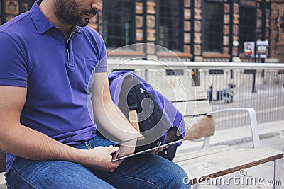 Hipster texting message on tablet computer or technology screen mockup. Smile young man using digital on building castle back Stock Photo