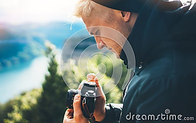 Hipster tourist hold in hands taking photography click on retro vintage photo camera in auto, photographer looking on camera techn Stock Photo