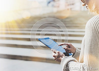 Hipster tourist texting message on tablet or technology mock up. Person using computer on building background close. Female hands Stock Photo
