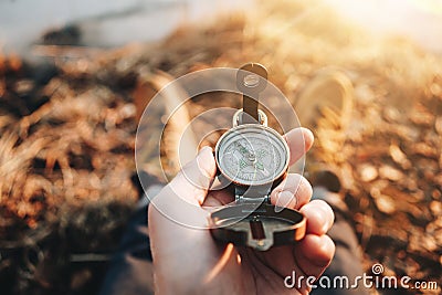 Hipster traveler hold vintage compass in hand on background of him legs in hiking boots Stock Photo