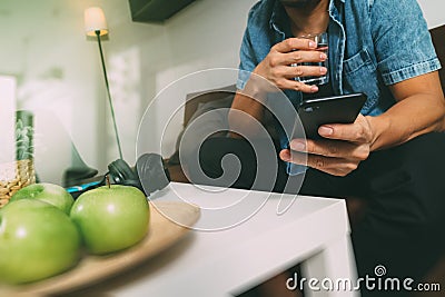 hipster using smart phone and digital tablet computer and holding credit card payments online business,sitting on sofa in living Stock Photo