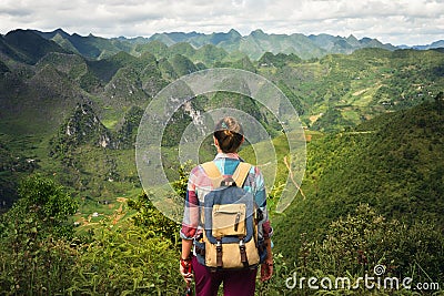 Hipster woman traveler with backpack enjoying a beautiful view o Stock Photo