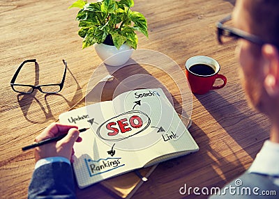Hipster Writing SEO Concepts on his Note Stock Photo
