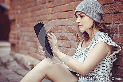 Hipster young girl works on the tablet on the internet Stock Photo