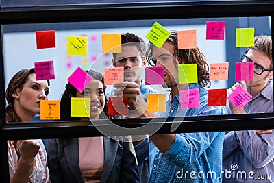 Hipsters reading a post it on a window Stock Photo