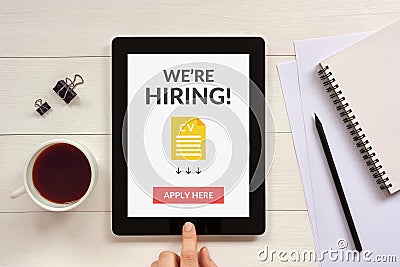 We are hiring apply now concept on tablet screen with office obj Stock Photo