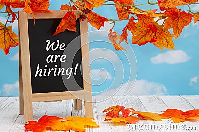 We are hiring sign with standing chalkboard with fall leaves Stock Photo