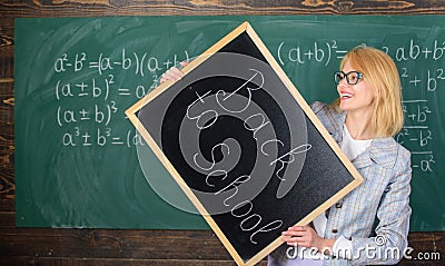 Hiring teachers for new school year. Woman teacher holds blackboard inscription back to school. Back to school teachers Stock Photo