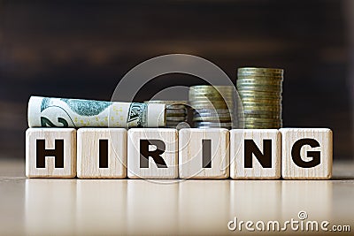 HIRING word on diced on a beautiful dark background with coins Stock Photo