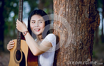 His guitar Happily hug the guitar, standing in the woods, open air, fresh music Stock Photo