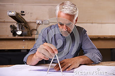 His work is always very accurate. a draftsman using a triangle and compass to draw up building plans. Stock Photo
