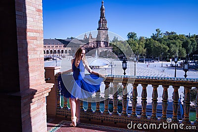 Hispanic adult female classical ballet dancer in blue tutu doing figures on the terrace of a plaza next to a beautiful tiled Stock Photo