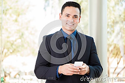 Hispanic businessman texting Stock Photo