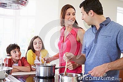 Hispanic Family Cooking Meal At Home Stock Photo