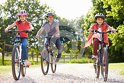 Hispanic Father And Children On Cycle Ride Stock Photo