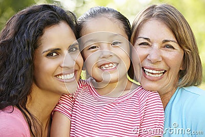 Hispanic Grandmother, Mother And Daughter Relaxing In Park Stock Photo