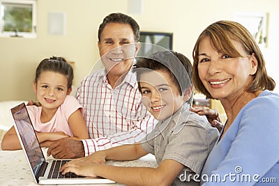Hispanic Grandparents And Grandchildren Using Computer At Home Stock Photo