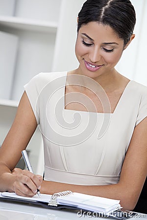 Hispanic Latina Woman or Businesswoman in Office Writing Stock Photo