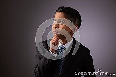 Hispanic Little Boy Deeply Meditating on Complex Subject Stock Photo