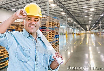 Hispanic Male Contractor Wearing Hard Hat Standing in Empty Industrial Warehouse Stock Photo