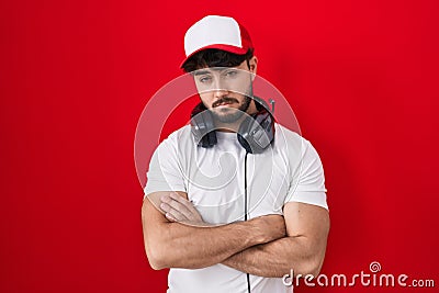 Hispanic man with beard wearing gamer hat and headphones looking sleepy and tired, exhausted for fatigue and hangover, lazy eyes Stock Photo