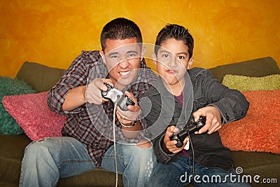 Hispanic Man and Boy Playing Video game Stock Photo