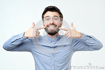 Hispanic man smiling confident showing and pointing with fingers teeth and mouth Stock Photo