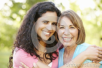 Hispanic Mother And Adult Daughter Relaxing In Park Stock Photo