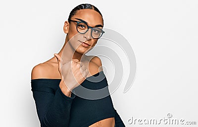 Hispanic transgender man wearing make up and long hair wearing women clothes doing happy thumbs up gesture with hand Stock Photo