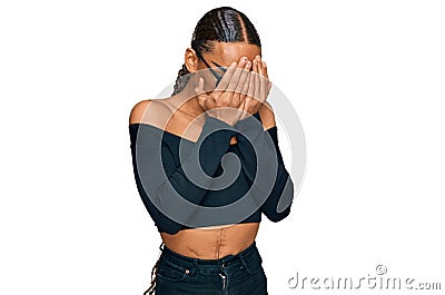Hispanic transgender man wearing make up and long hair wearing women clothes with sad expression covering face with hands while Stock Photo