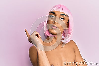 Hispanic transgender man wearing make up and pink wig smiling happy pointing with hand and finger to the side Stock Photo