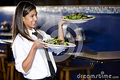 Hispanic waitress serving salads Stock Photo