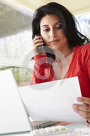 Hispanic Woman Working In Home Office Stock Photo