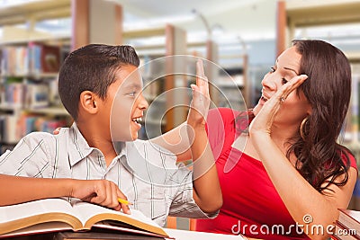 Hispanic Young Boy and Female Adult High Five Studying Stock Photo