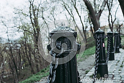 Historic black metal chain fence against an ocker colored Stock Photo