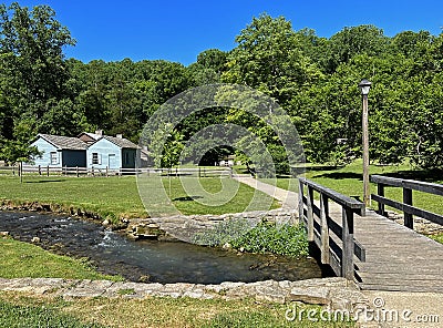 1800 Historic Buildings and a Foot Bridge over the creek in Spring Mill State Park Stock Photo