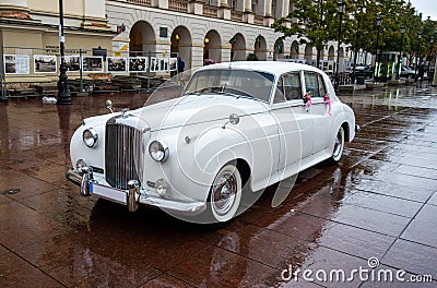 Historic car waiting for just married couple in front of a luxury hotel in the center of Warsaw Editorial Stock Photo