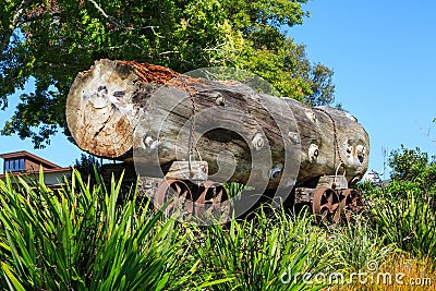Historic logging industry. A huge log on a rail trolley, displayed in a park Stock Photo