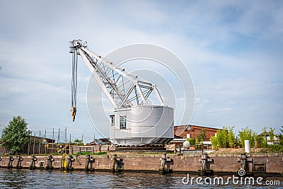 Historic slewing crane stands at the quay of an old transshipment port Stock Photo