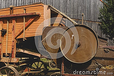 Historic threshing machine with subsequent straw press in operation. The wheel turns and shows motion blur Stock Photo
