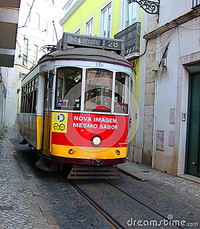 Historic tram no. 28 between the narrow house of the alfama of lisbon, portugal Editorial Stock Photo