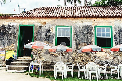 A historic, very old and rustic trade, small tables and umbrella Editorial Stock Photo