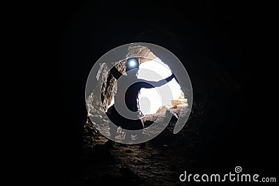 Historic World-War I tunnel and a woman tourist with a head torch on, at via ferrata Delle Trincee galleries Stock Photo