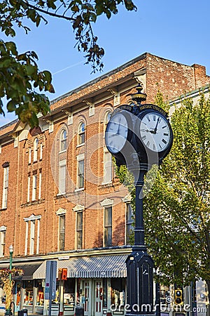 Historic Ypsilanti Street Clock and Brick Building Facade at Sunset Stock Photo