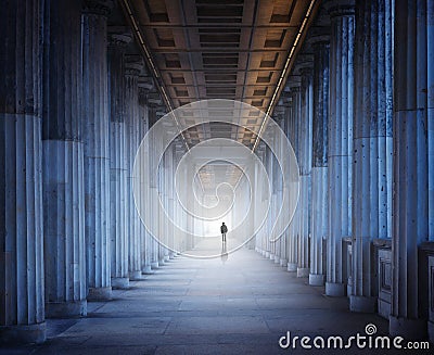 A historical building and a man walking into the light Stock Photo