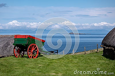 A historical cart in the Skye museum of island life with ancient houses and sea in the background in Northern Scotland Stock Photo