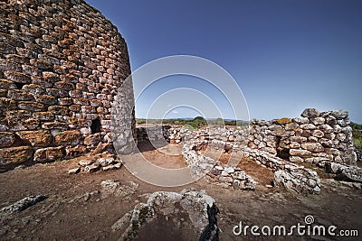 Historical castle near rock formations under the clear sky in Su Nuraxi, Sardinia, Italy Stock Photo