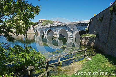 Historical roman Tiberius bridge over Marecchia river in Rimini, Italy. Editorial Stock Photo